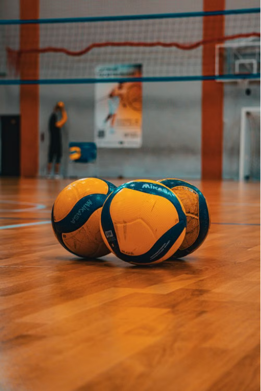 Volleyballs on the court, net in the background
